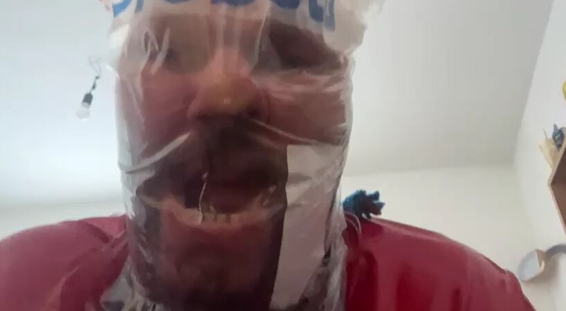 SklaveAndreas in Latex im Bett