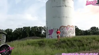 Urinating outside in front of a wind turbine with an amateur