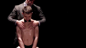 The slave boy in his jockstrap works on his master's rock-hard cock as per his master