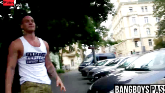 Three muscled hunks arm wrestling in the street