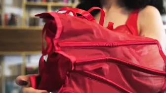 The dark hair slides on a red bra and a red corset