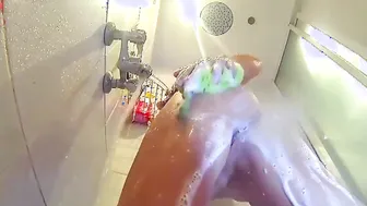 Voyeur camera into the shower. A young naked women into the shower is washed with soap.