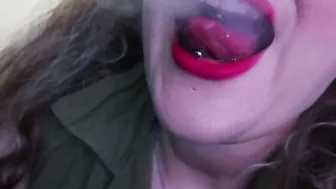 ADORABLE WOMAN PAINTS HER LIPS RED AND SMOKES a CIGARETTE