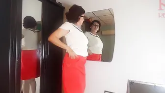 A nude lady does make-up inside front of a mirror slips on lingerie tights a skirt. three