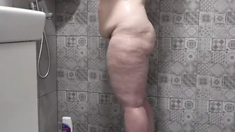 A concealed camera inside the shower room spies on a older ex-wife with a plump figure and gigantic jugs and