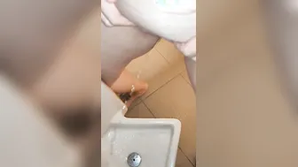 Pee into a urinal into a guyss outdoor restroom