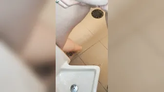 Pee into a urinal into a guyss outdoor restroom