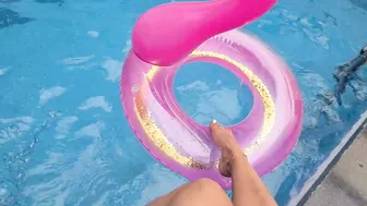 HAVING FUN WITH THE FOOT ON THE SIDE OF THE POOL WITH THE BUOY