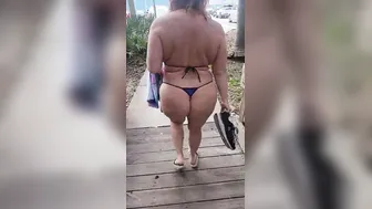 Milk walking inside outdoor wearing a g-string