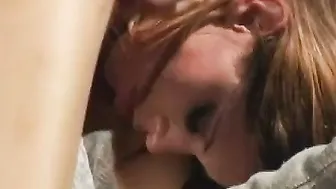 Young dark haired is on her knees sucking off studs dick outside