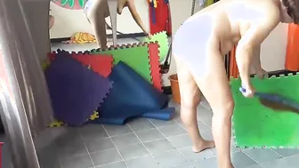 Nudist maid cleans the yoga room. A nude cleaner cleans