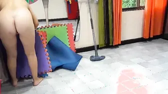 Nudist maid cleans the yoga room. A nude cleaner cleans