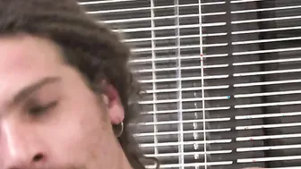 Tattooed dude with long dreads and Prince Albert piercing strokes himself in apartment.